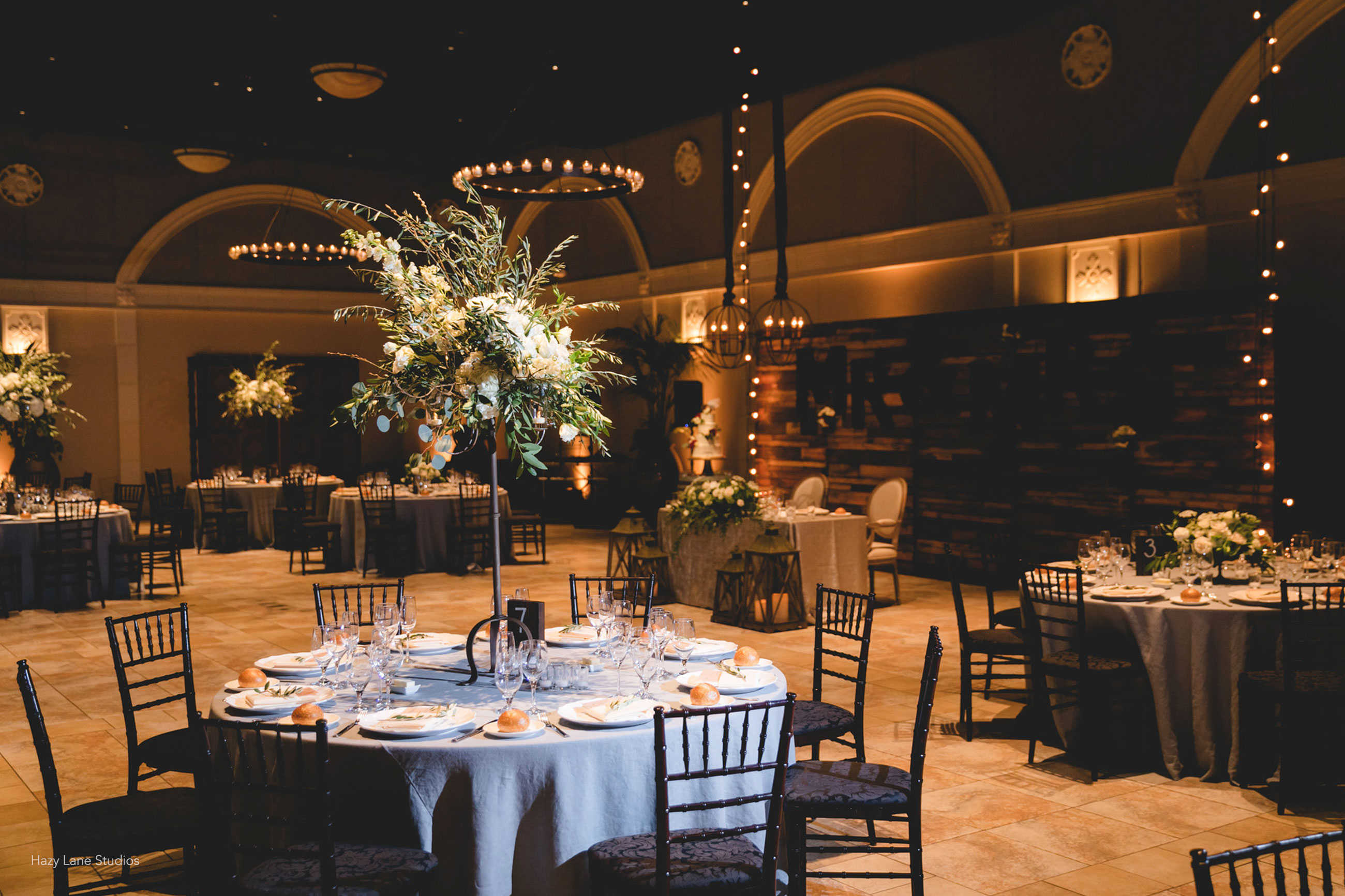 Unique wedding reception with sweetheart table wood wall backdrop at Casa Real at Ruby Hill Winery (www.casarealevents.com).  Photo by: Hazy Lane Studios; Florals: Michael Daigian Design; Lighting and Wall: Fantasy Sound Event Services